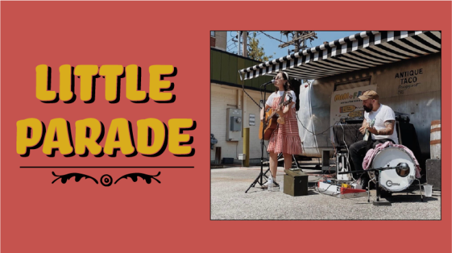 Little parade. Photograph of a woman singing and playing guitar and a man wearing a hat playing the drums. 